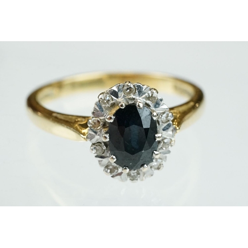 166 - Sapphire and diamond 18ct yellow and white gold set cluster ring, oval mixed cut blue-black sapphire... 