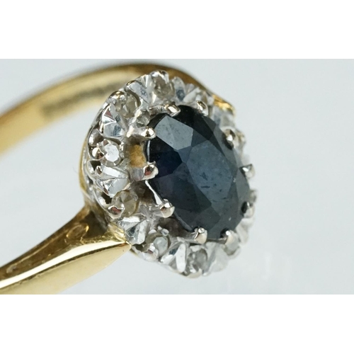 166 - Sapphire and diamond 18ct yellow and white gold set cluster ring, oval mixed cut blue-black sapphire... 