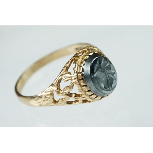 270 - Hematite intalgio 9ct yellow gold ring, stylised Centurion's head to the intaglio, abstract pierced ... 