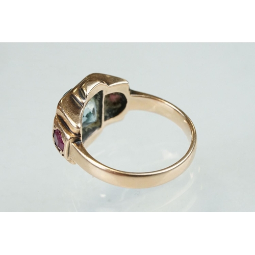 291 - Topaz and ruby rose metal ring, the round mixed cut blue topaz diameter approx 7mm, claw and flush s... 