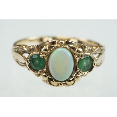 293 - Opal and emerald 9ct yellow gold ring, the oval cabochon cut precious white opal displaying green an... 