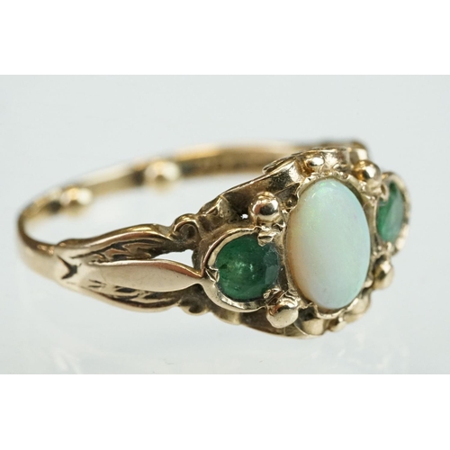 293 - Opal and emerald 9ct yellow gold ring, the oval cabochon cut precious white opal displaying green an... 