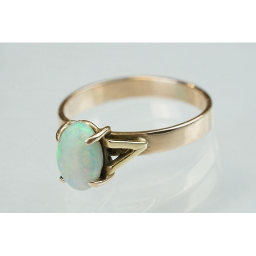 296 - Opal 9ct yellow gold ring, the oval cabochon cut opal displaying violet, indigo, green, orange and r... 