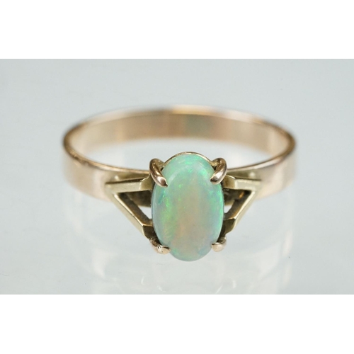 296 - Opal 9ct yellow gold ring, the oval cabochon cut opal displaying violet, indigo, green, orange and r... 