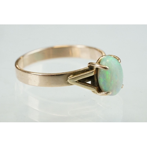 296 - Opal 9ct yellow gold ring, the oval cabochon cut opal displaying violet, indigo, green, orange and r... 