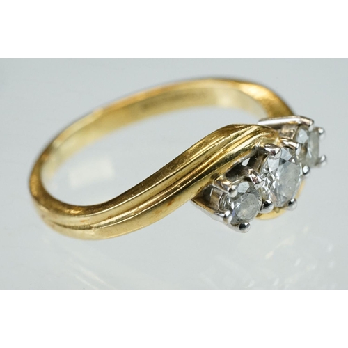 300 - Diamond 18ct yellow gold three stone crossover ring, round brilliant cut graduated diamonds, the cen... 