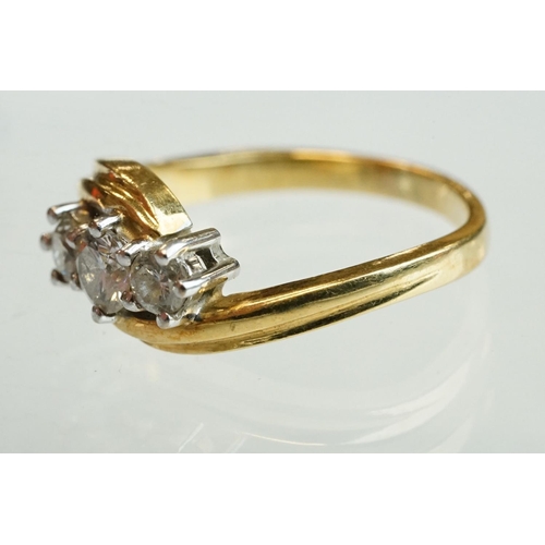 300 - Diamond 18ct yellow gold three stone crossover ring, round brilliant cut graduated diamonds, the cen... 