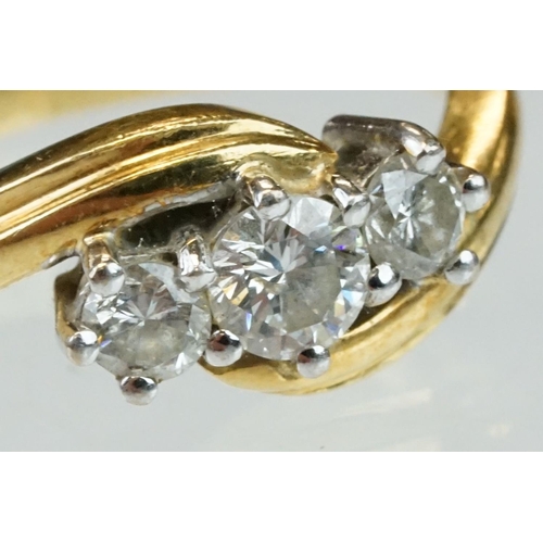 300 - Diamond 18ct yellow gold three stone crossover ring, round brilliant cut graduated diamonds, the cen... 