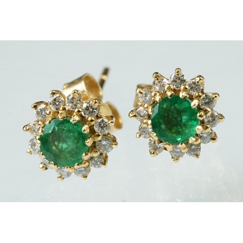 35 - Emerald and diamond 18ct yellow gold cluster earrings, the round mixed cut emerald measuring approx ... 