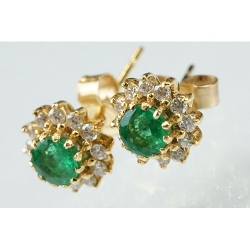 35 - Emerald and diamond 18ct yellow gold cluster earrings, the round mixed cut emerald measuring approx ... 