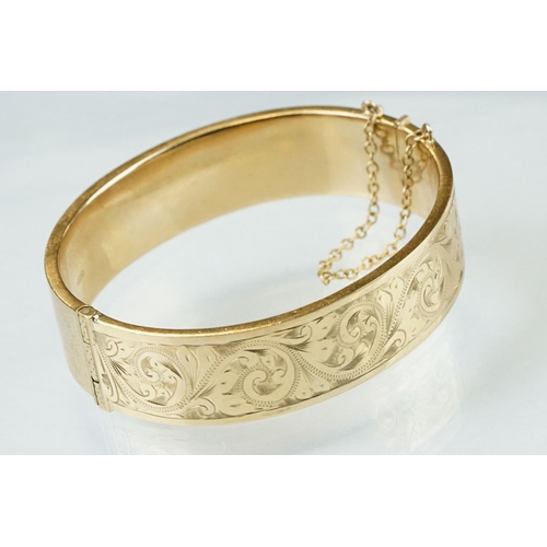 36 - 9ct yellow gold hinged bangle, engraved foliate scroll decoration to the upper half, tongue and box ... 