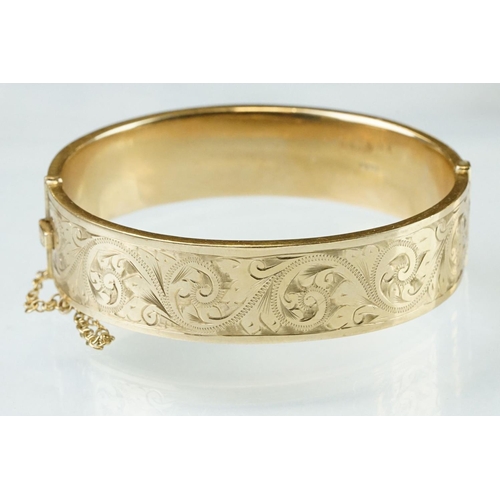 36 - 9ct yellow gold hinged bangle, engraved foliate scroll decoration to the upper half, tongue and box ... 