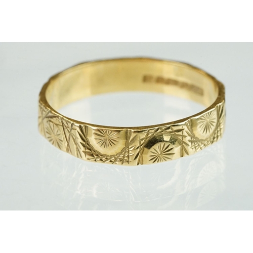 365 - 18ct yellow gold wedding band, cast and engraved decoration in low relief, width approx 4.5mm, ring ... 