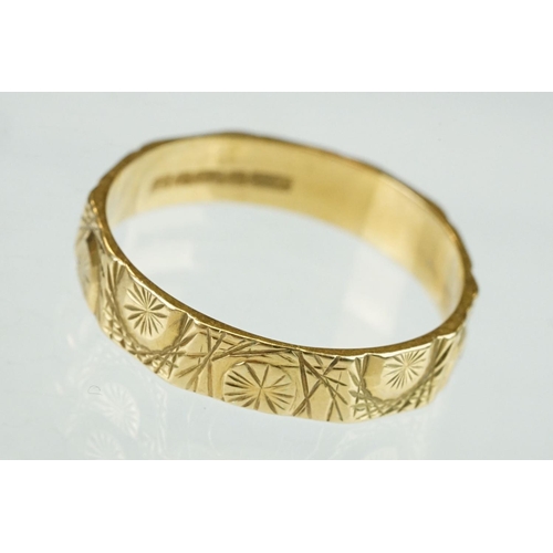 365 - 18ct yellow gold wedding band, cast and engraved decoration in low relief, width approx 4.5mm, ring ... 