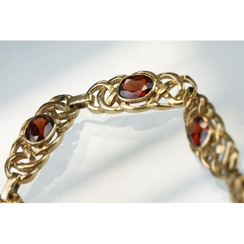 51 - Garnet 9ct yellow gold bracelet, seven oval mixed cut garnets, rubover set, each garnet measuring ap... 