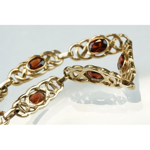 51 - Garnet 9ct yellow gold bracelet, seven oval mixed cut garnets, rubover set, each garnet measuring ap... 