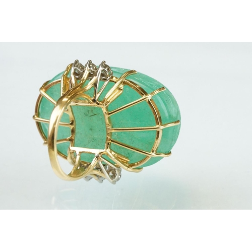 56 - Emerald and diamond yellow metal ring, the large oval cabochon cut emerald with floral and foliate d... 