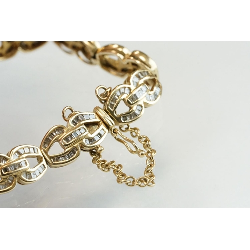 57 - Diamond 14ct yellow gold bracelet, the fancy links full set with tapered baguette cut diamonds, tong... 