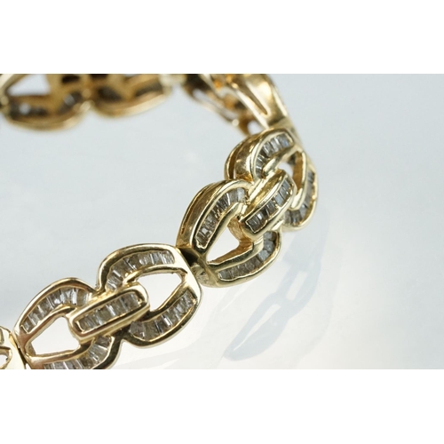 57 - Diamond 14ct yellow gold bracelet, the fancy links full set with tapered baguette cut diamonds, tong... 