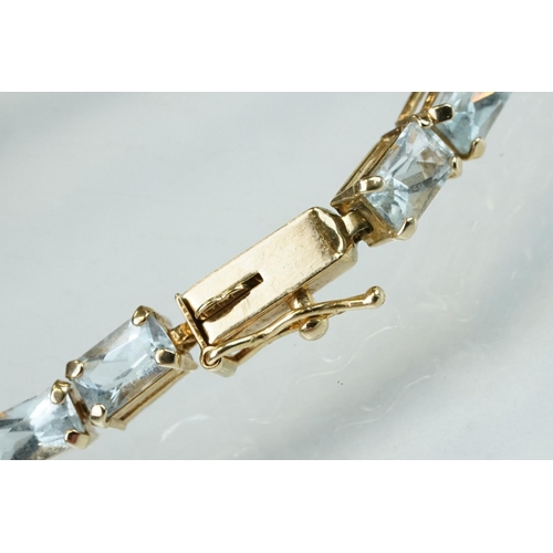 58 - Topaz 9ct yellow gold line bracelet, thirty rectangular mixed cut pale blue topaz, claw set, tongue ... 