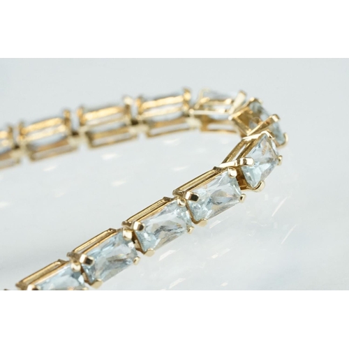 58 - Topaz 9ct yellow gold line bracelet, thirty rectangular mixed cut pale blue topaz, claw set, tongue ... 