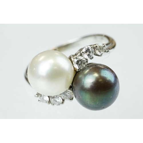 67 - Pearl and diamond unmarked white gold crossover style ring, the black cultured pearl with green over... 