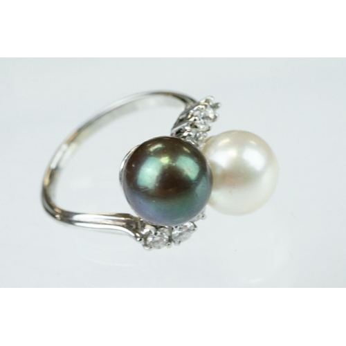 67 - Pearl and diamond unmarked white gold crossover style ring, the black cultured pearl with green over... 