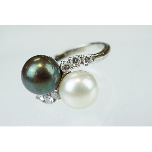 67 - Pearl and diamond unmarked white gold crossover style ring, the black cultured pearl with green over... 