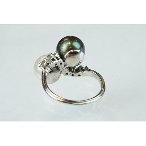 67 - Pearl and diamond unmarked white gold crossover style ring, the black cultured pearl with green over... 