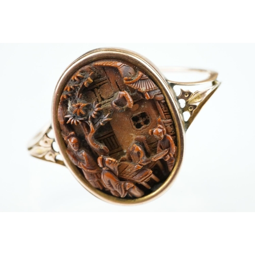 71 - Oriental resin rose metal scarf ring, the panel depicting elders sat around a table in village scene... 