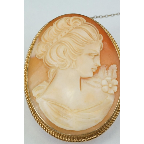 77 - Shell cameo 9ct yellow gold brooch, the cameo depicting female profile, rubover set, rope twist surr... 