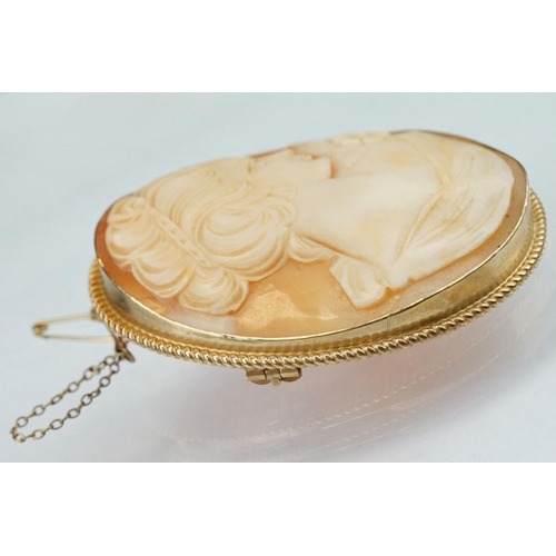 77 - Shell cameo 9ct yellow gold brooch, the cameo depicting female profile, rubover set, rope twist surr... 