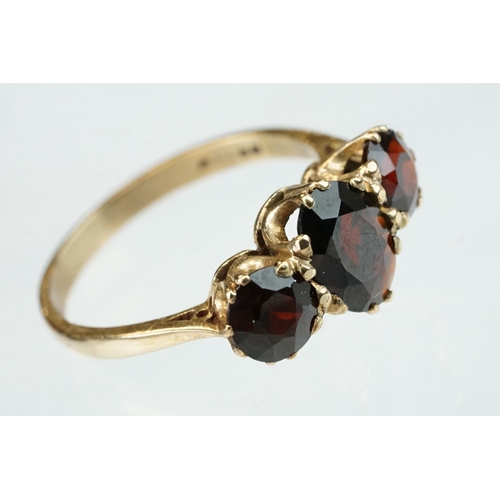 86 - Garnet 9ct yellow gold three stone, ring, the central oval mixed cut garnet measuring approx 8mm x 5... 