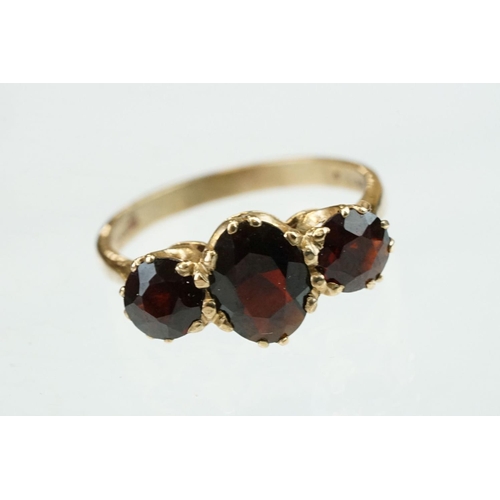 86 - Garnet 9ct yellow gold three stone, ring, the central oval mixed cut garnet measuring approx 8mm x 5... 