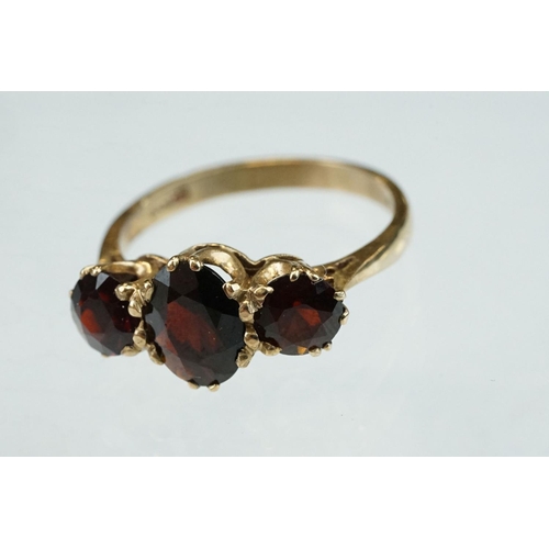 86 - Garnet 9ct yellow gold three stone, ring, the central oval mixed cut garnet measuring approx 8mm x 5... 