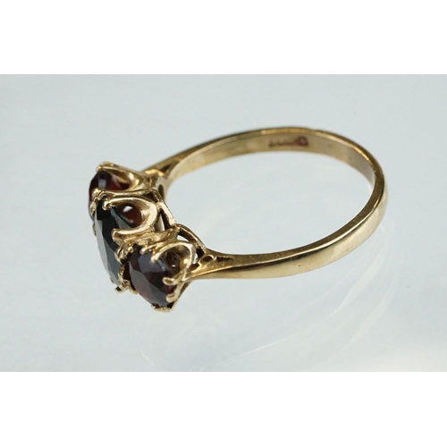 86 - Garnet 9ct yellow gold three stone, ring, the central oval mixed cut garnet measuring approx 8mm x 5... 