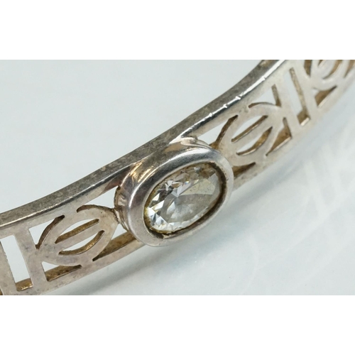 98 - Four silver hinged bangles, together with a Rennie Macintosh style cubic zirconia set silver bangle ... 