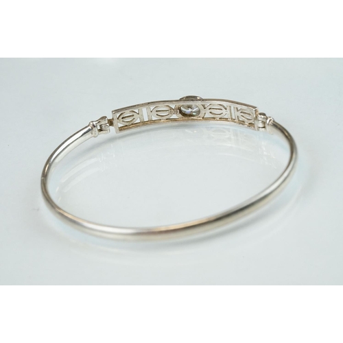 98 - Four silver hinged bangles, together with a Rennie Macintosh style cubic zirconia set silver bangle ... 