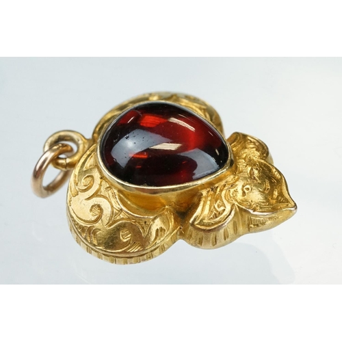 12 - Late 19th century garnet carbuncle yellow metal pendant, the teardrop shaped cabochon cut garnet mea... 