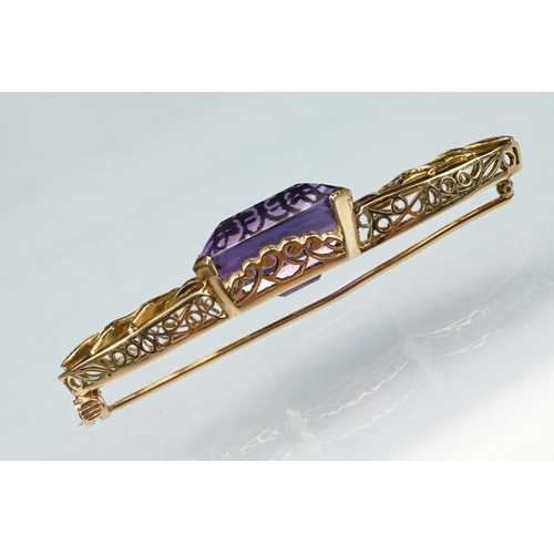 14 - Early 20th century amethyst yellow metal brooch, the rectangular mixed cut amethyst measuring approx... 