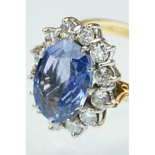 16 - Sapphire and diamond 18ct yellow and white gold set cluster ring, the oval mixed cut sapphire measur... 