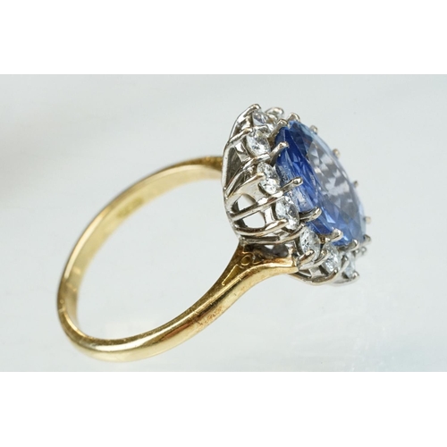 16 - Sapphire and diamond 18ct yellow and white gold set cluster ring, the oval mixed cut sapphire measur... 