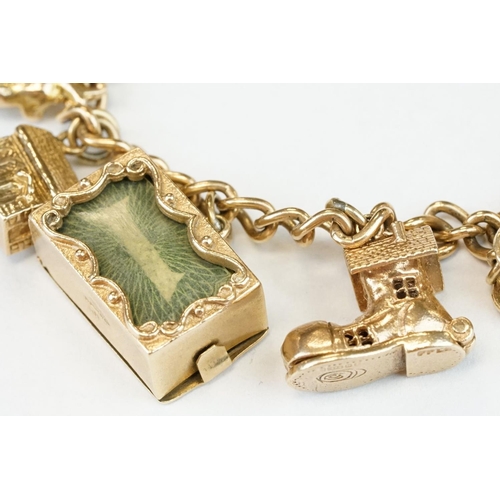 200A - 9ct yellow gold charm bracelet with padlock clasp and safety chain, eleven 9ct gold charms and one y... 