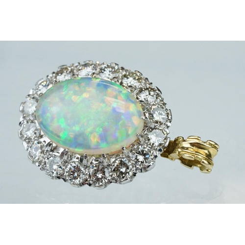 3 - Opal and diamond unmarked yellow and white gold set pendant, the oval cabochon cut opal displaying f... 