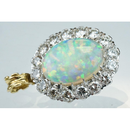 3 - Opal and diamond unmarked yellow and white gold set pendant, the oval cabochon cut opal displaying f... 