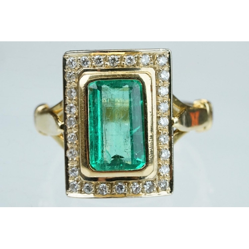 4 - Emerald and diamond unmarked yellow gold ring, the emerald cut emerald measuring approx 11mm x 7mm, ... 