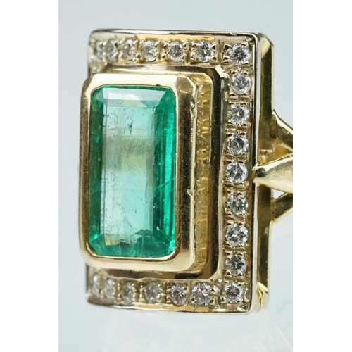 4 - Emerald and diamond unmarked yellow gold ring, the emerald cut emerald measuring approx 11mm x 7mm, ... 