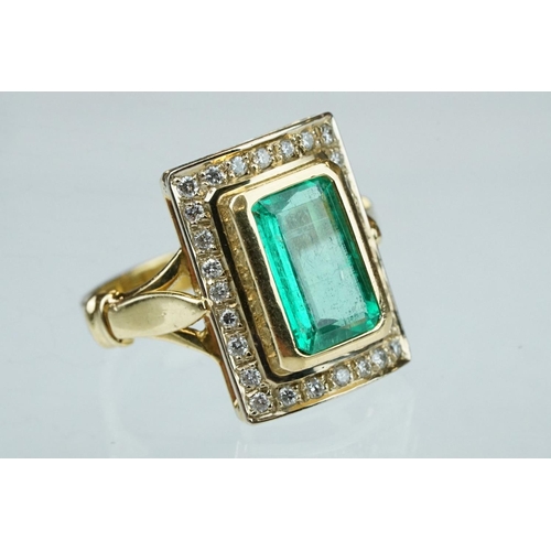 4 - Emerald and diamond unmarked yellow gold ring, the emerald cut emerald measuring approx 11mm x 7mm, ... 