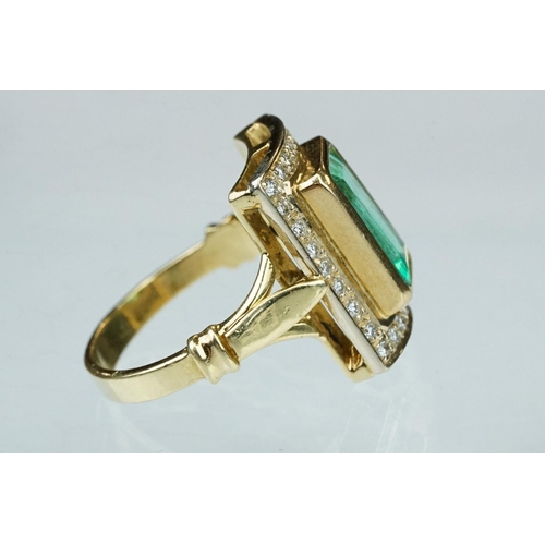 4 - Emerald and diamond unmarked yellow gold ring, the emerald cut emerald measuring approx 11mm x 7mm, ... 