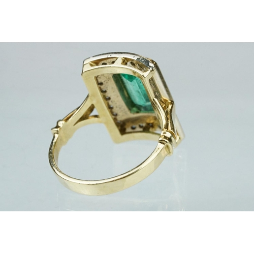 4 - Emerald and diamond unmarked yellow gold ring, the emerald cut emerald measuring approx 11mm x 7mm, ... 